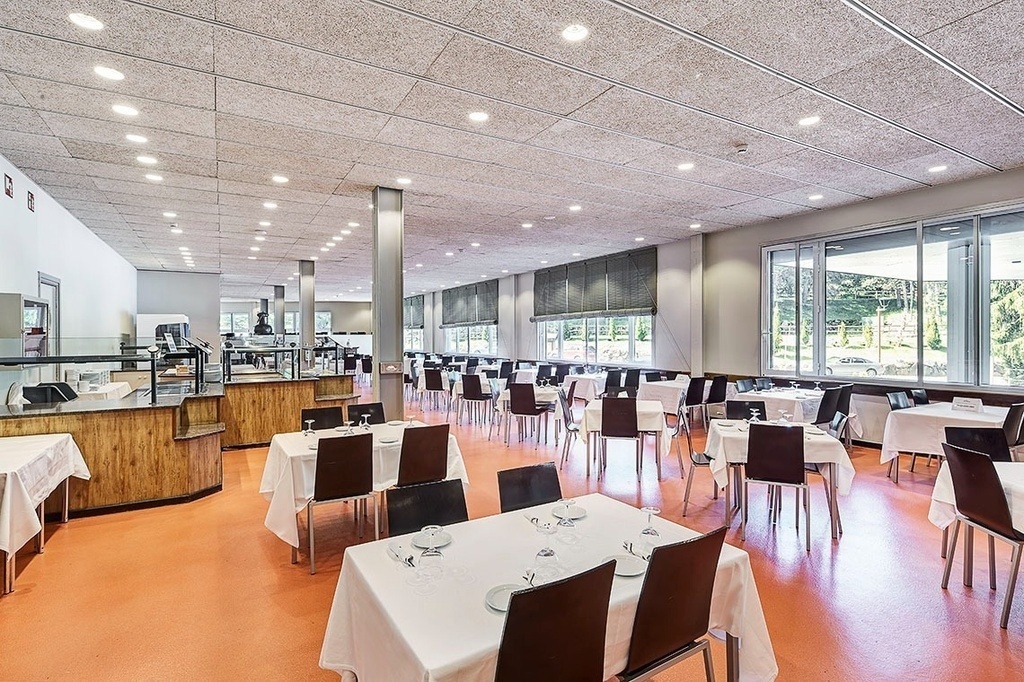 a large dining room with tables and chairs and a counter