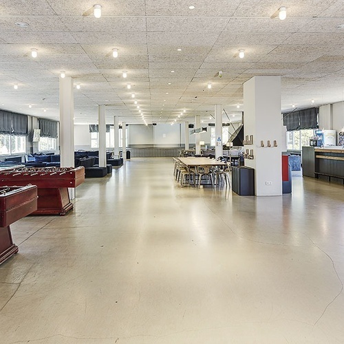 un gran salón con mesas de billar y futbolín