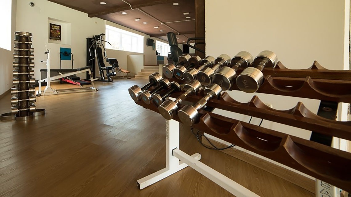 un rack en bois rempli de haltères dans une salle de sport