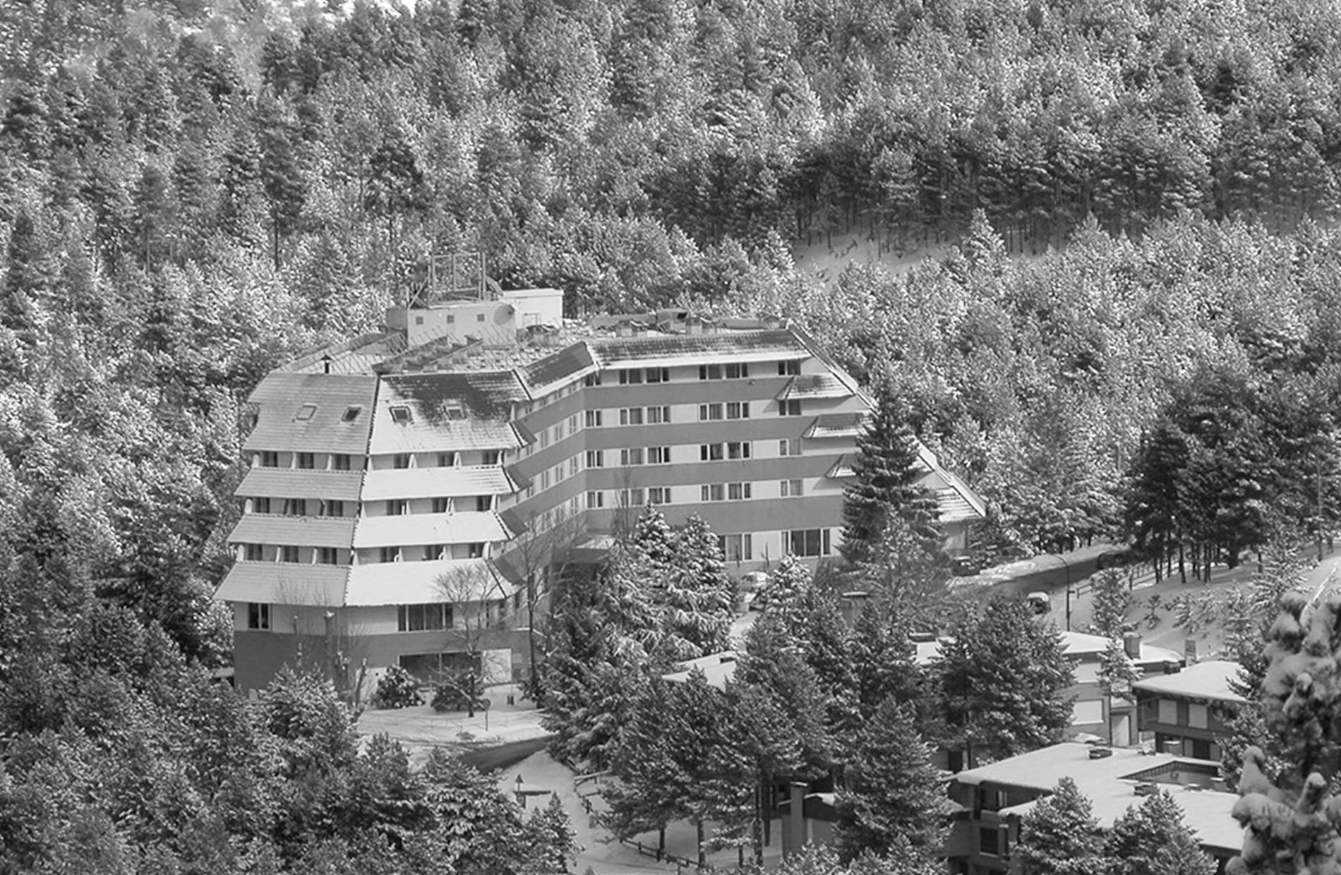 un grand bâtiment se trouve au milieu d' une forêt couverte de neige=s1900