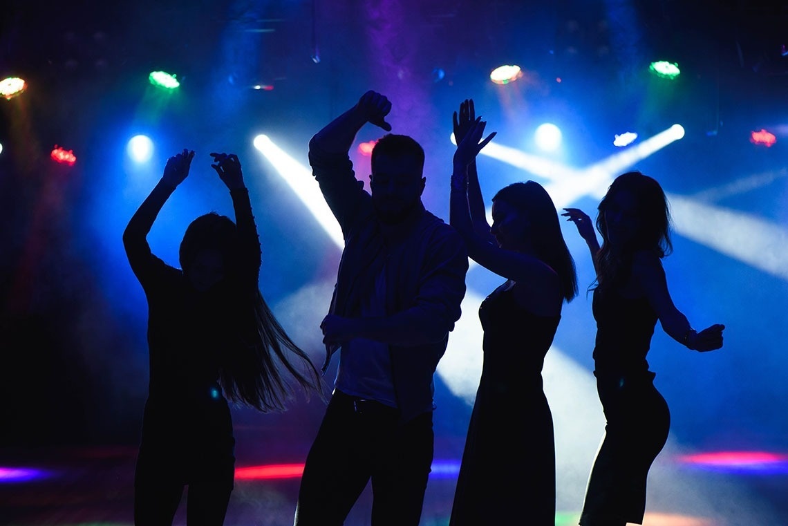 a group of people are dancing in a dark room