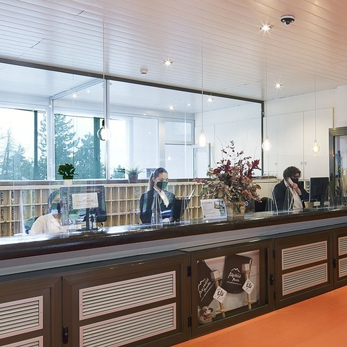un mostrador de recepción de un hotel con dos mujeres y un cartel que dice ' atencion al cliente '