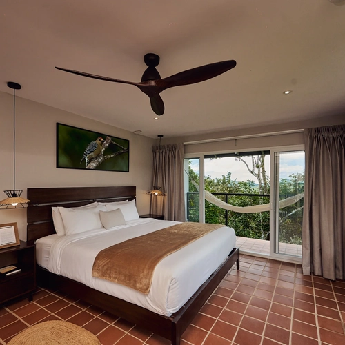 Habitación de hotel con cama king, vista a la selva y hamaca exterior. Alto Monte