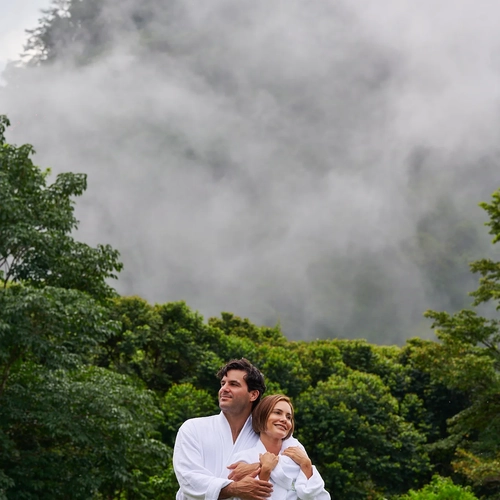 Pareja en batas blancas disfrutando de la vista Alto Monte.