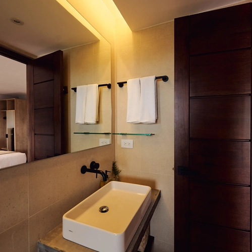 Modern bathroom vanity with sink and towels, featuring integrated lighting. Alto Monte