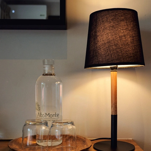 Lámpara y botella de agua 'Alto Monte' en mesita de noche, ideal para tu Alto Monte.