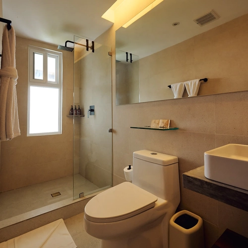 Baño moderno con ducha amplia, inodoro, lavabo y toallas limpias. Alto Monte