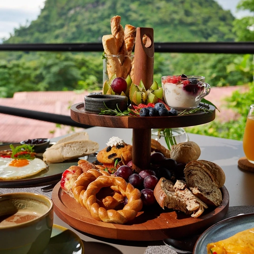 Desayuno en hotel con vista a la montaña: frutas, pan,Alto Monte y zumo.