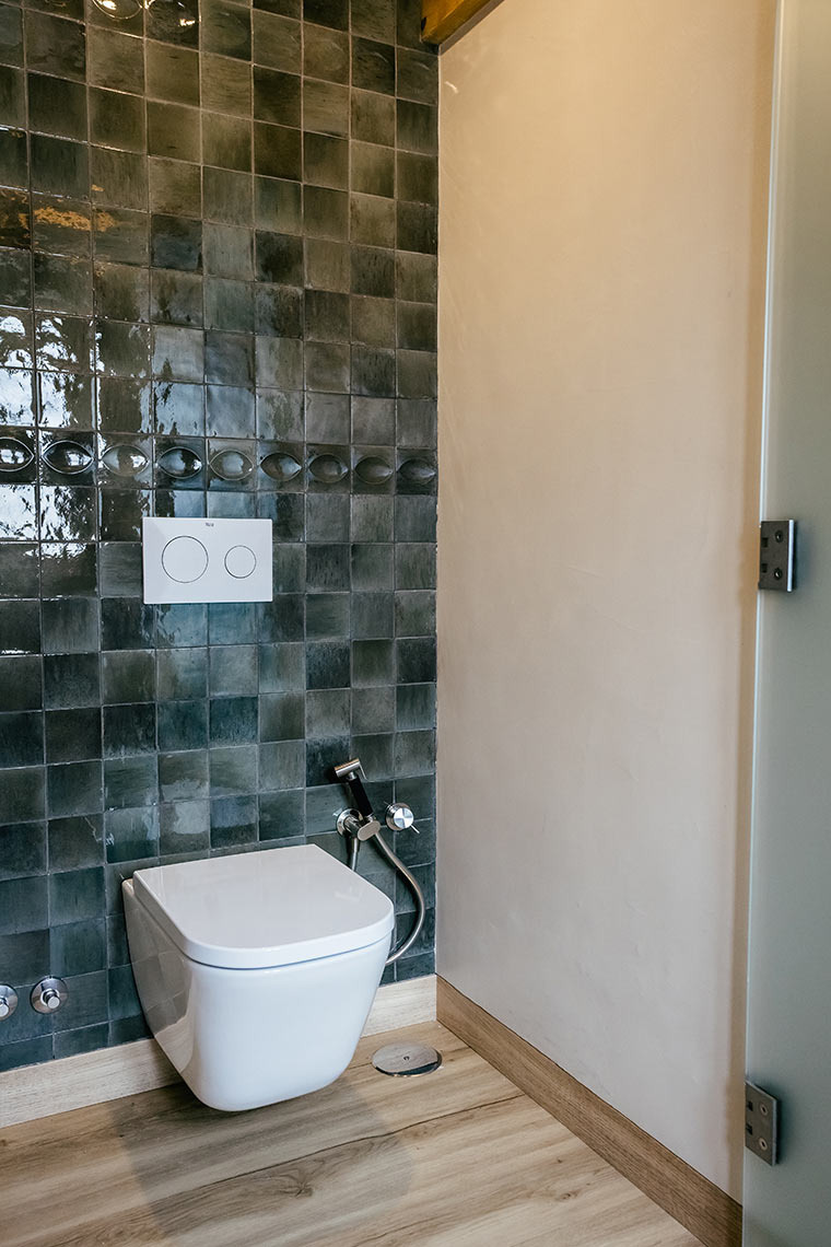 Modern hotel bathroom with tiled wall, bidet shower, and AndTales comfort.