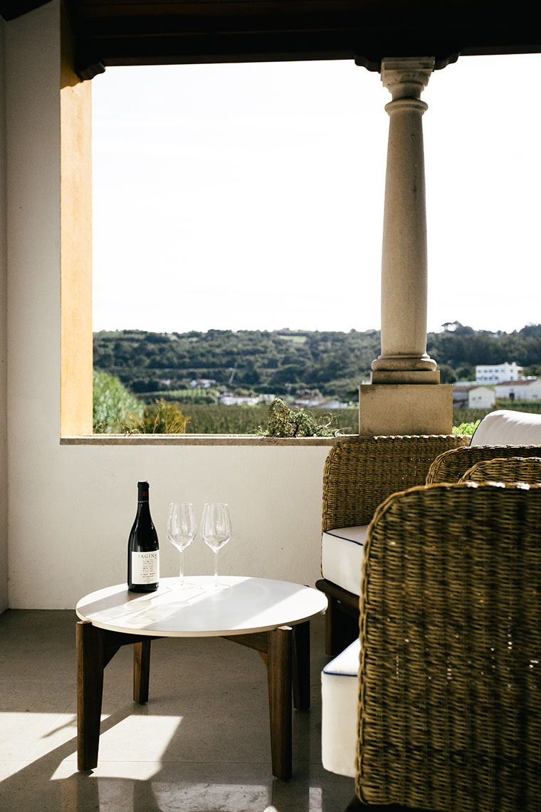 Uma garrafa de vinho e taças em uma mesa, com vista AndTales.