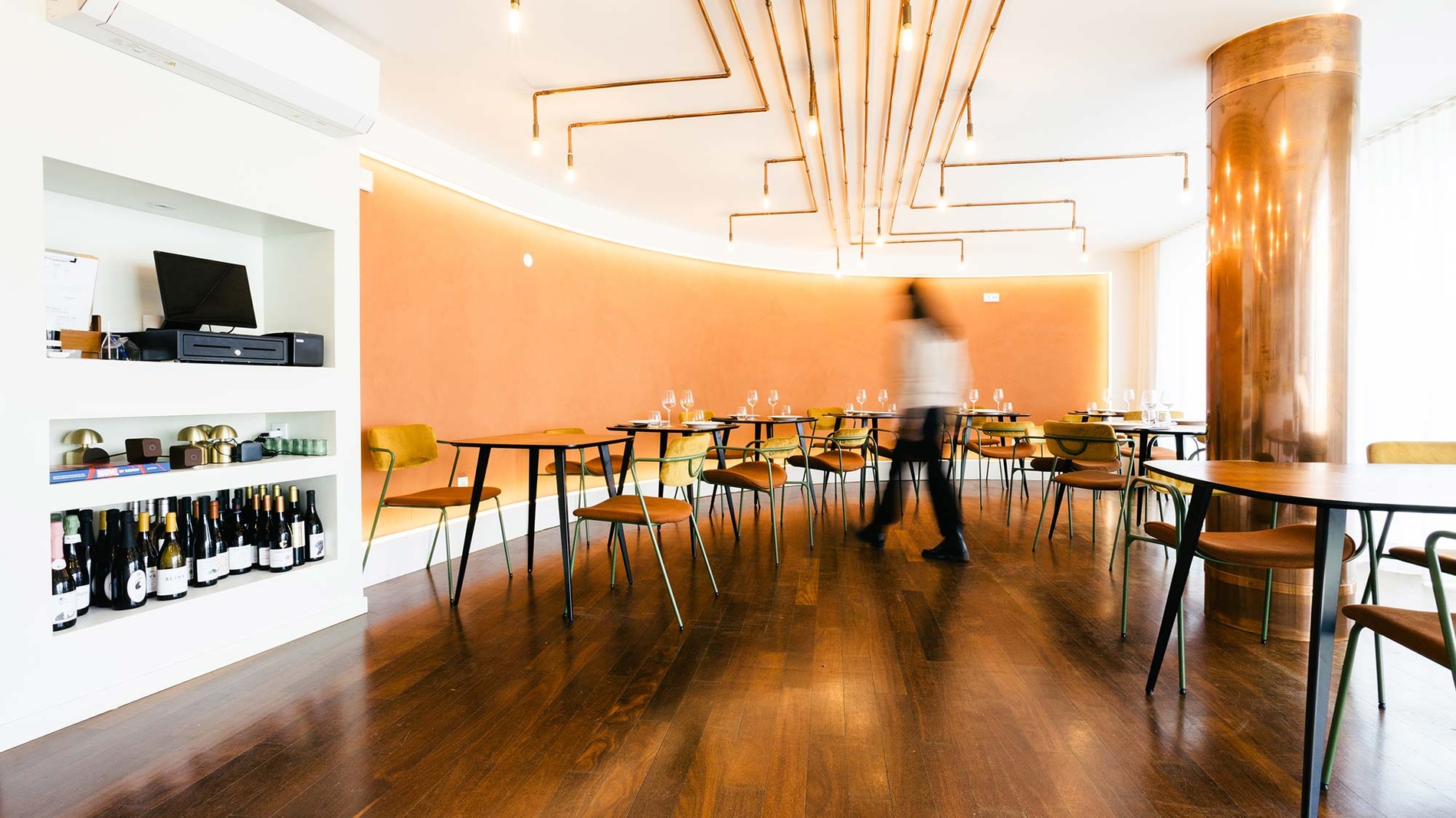 Sala de jantar AndTales com mesas e cadeiras modernas, decoração elegante e atmosfera acolhedora.
