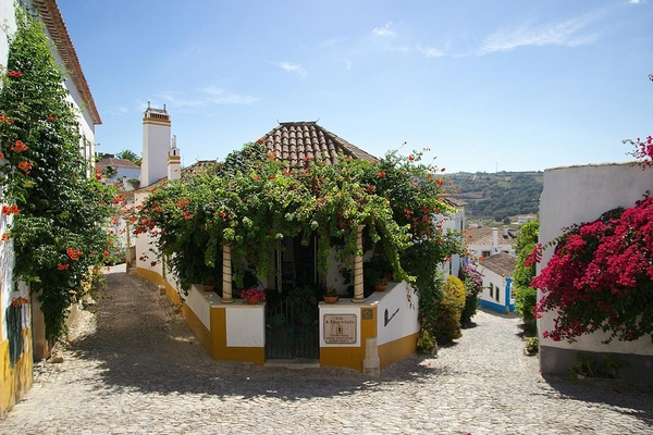 Casa AndTales em Óbidos, Portugal: charmosa rua de paralelepípedos e flores vibrantes