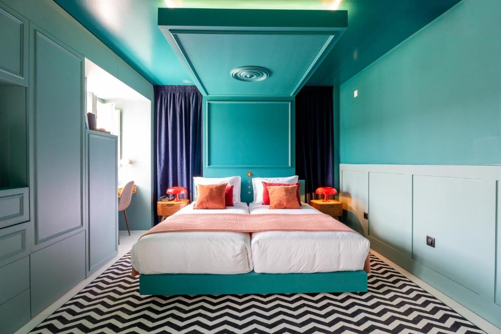 Quarto AndTales: duas camas, decoração azul-petróleo e bege, tapete zig-zag.