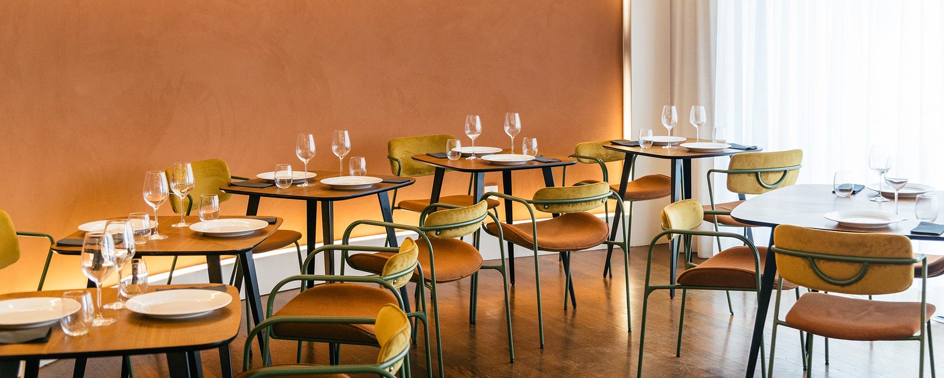 Ambiente elegante com mesas postas e cadeiras no restaurante AndTales.