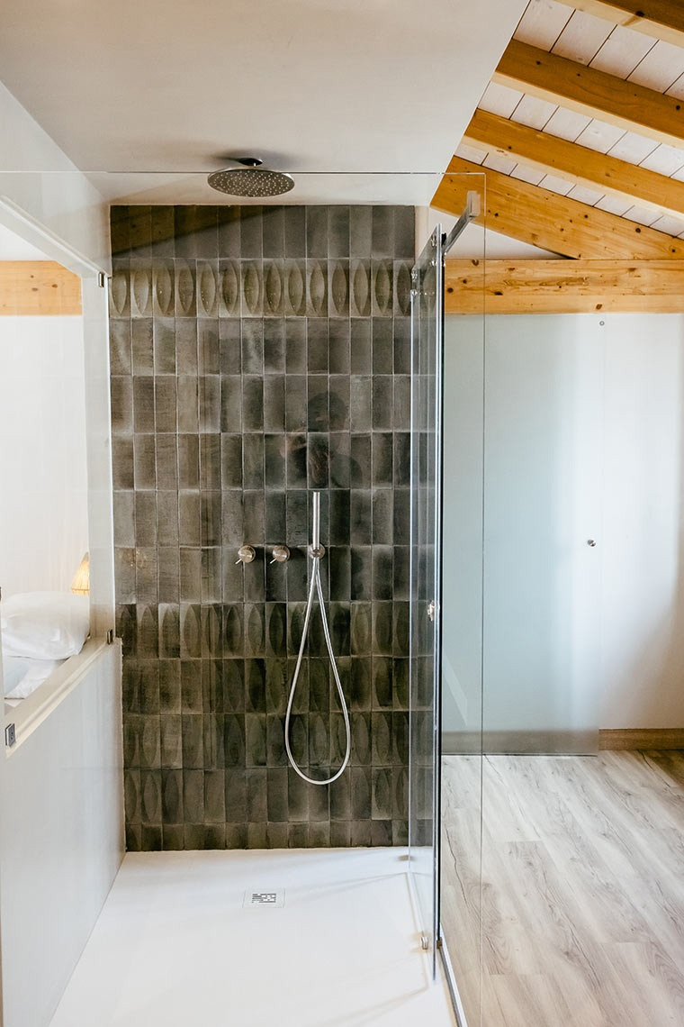Modern hotel shower with grey tiles and AndTales design.