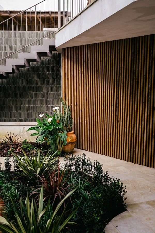 Jardim AndTales moderno com escadas e parede de madeira.