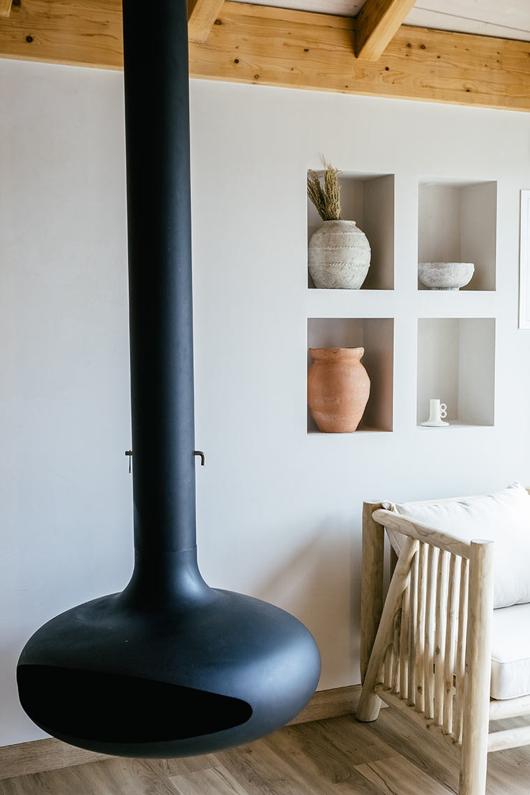 Modern fireplace at AndTales hotel, with a natural wood sofa and decor.