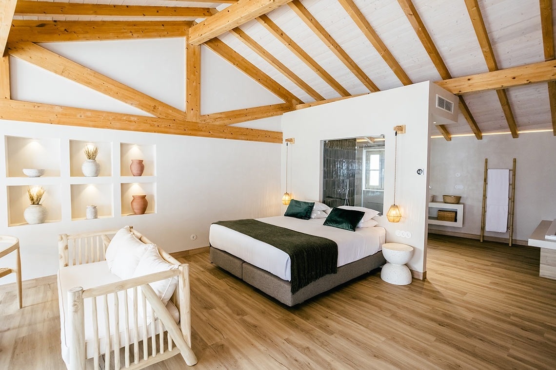 AndTales room with queen bed, wooden beams, and rustic decor.