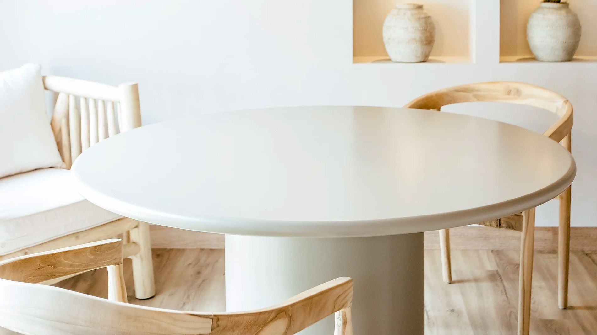 Sala de jantar aconchegante no AndTales com mesa redonda e lustre de vime.