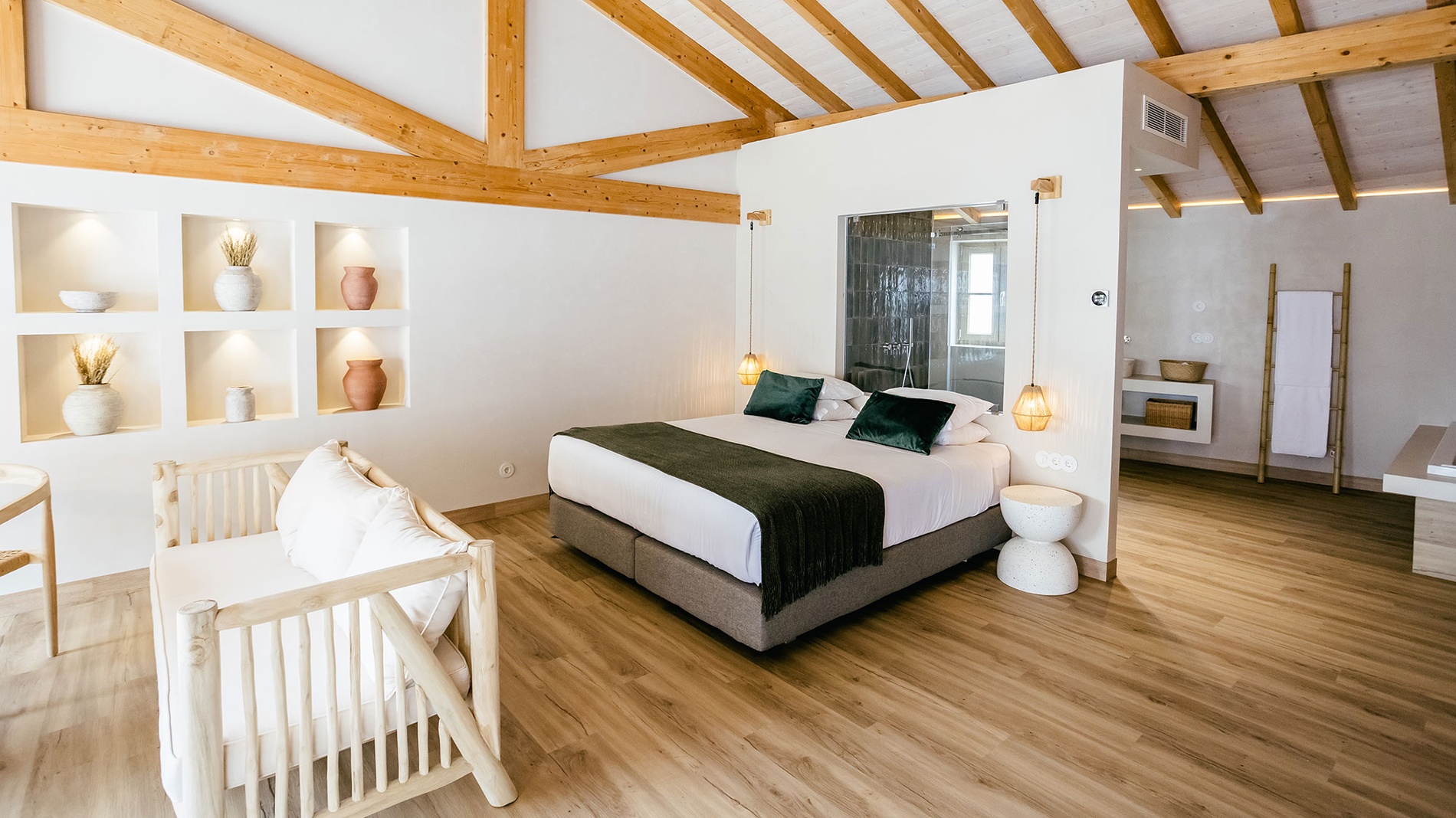 Cama de casal aconchegante com decoração AndTales em quarto iluminado.