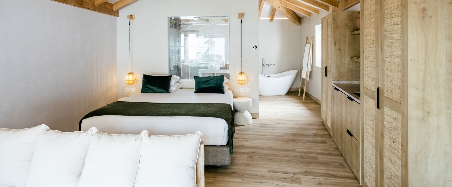 Cozy hotel room with a plush bed, navy pillows, desk, and phone. AndTales accommodation.
