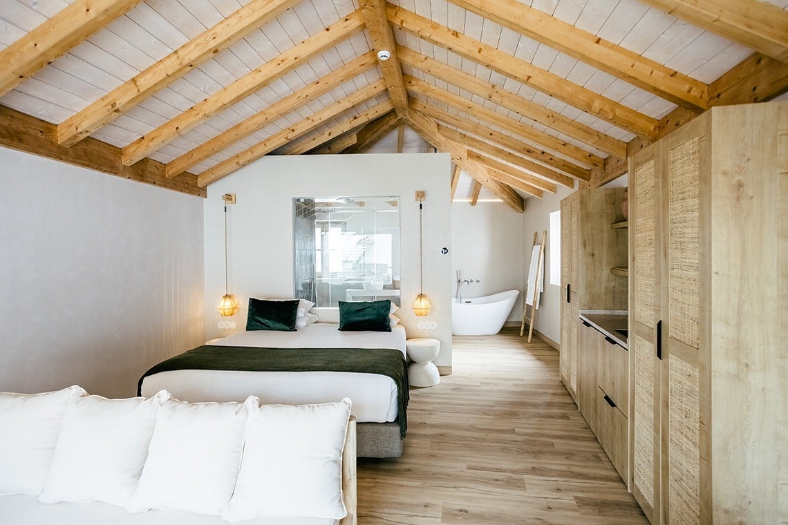 Quarto AndTales com cama queen e banheira independente, estilo contemporâneo.
