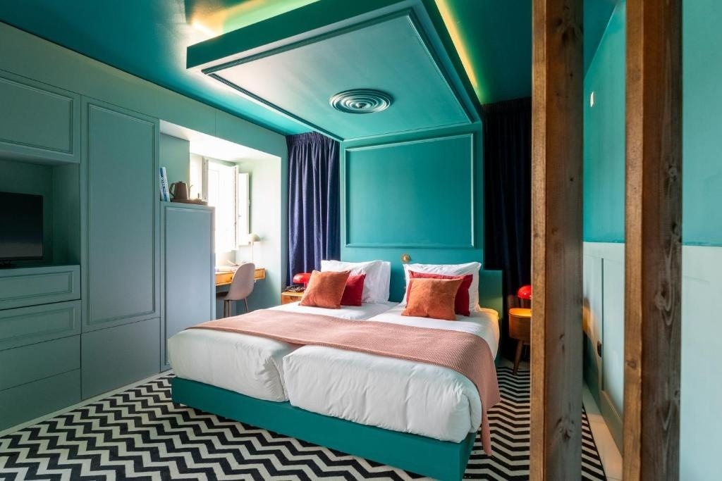Quarto elegante em AndTales com duas camas e decoração azul-turquesa.