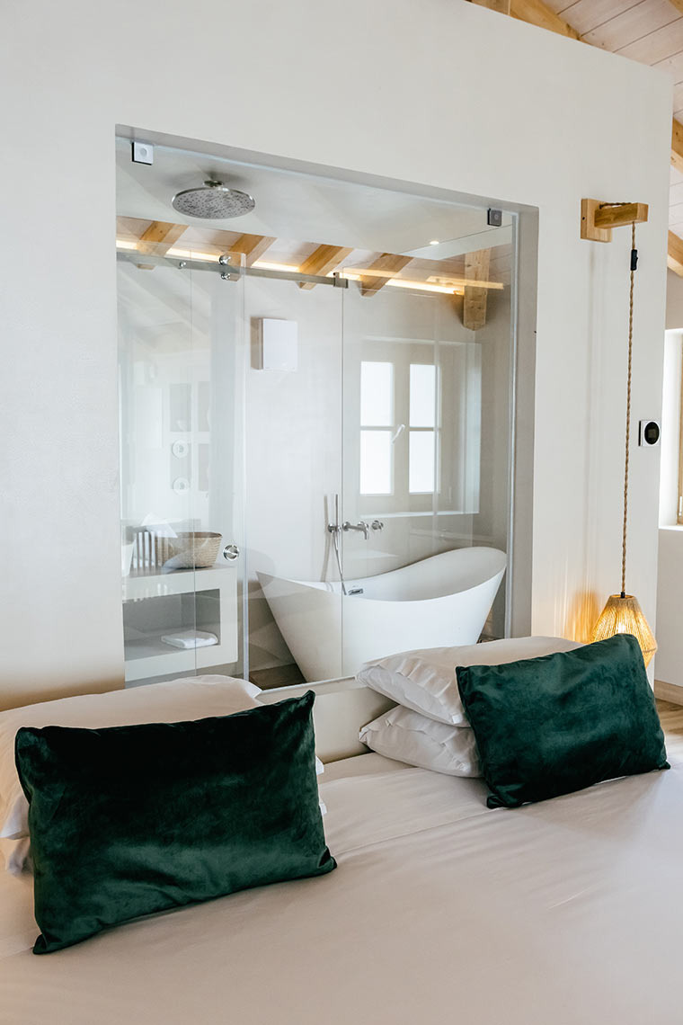 Modern bathroom with freestanding tub inside bedroom at AndTales resort.