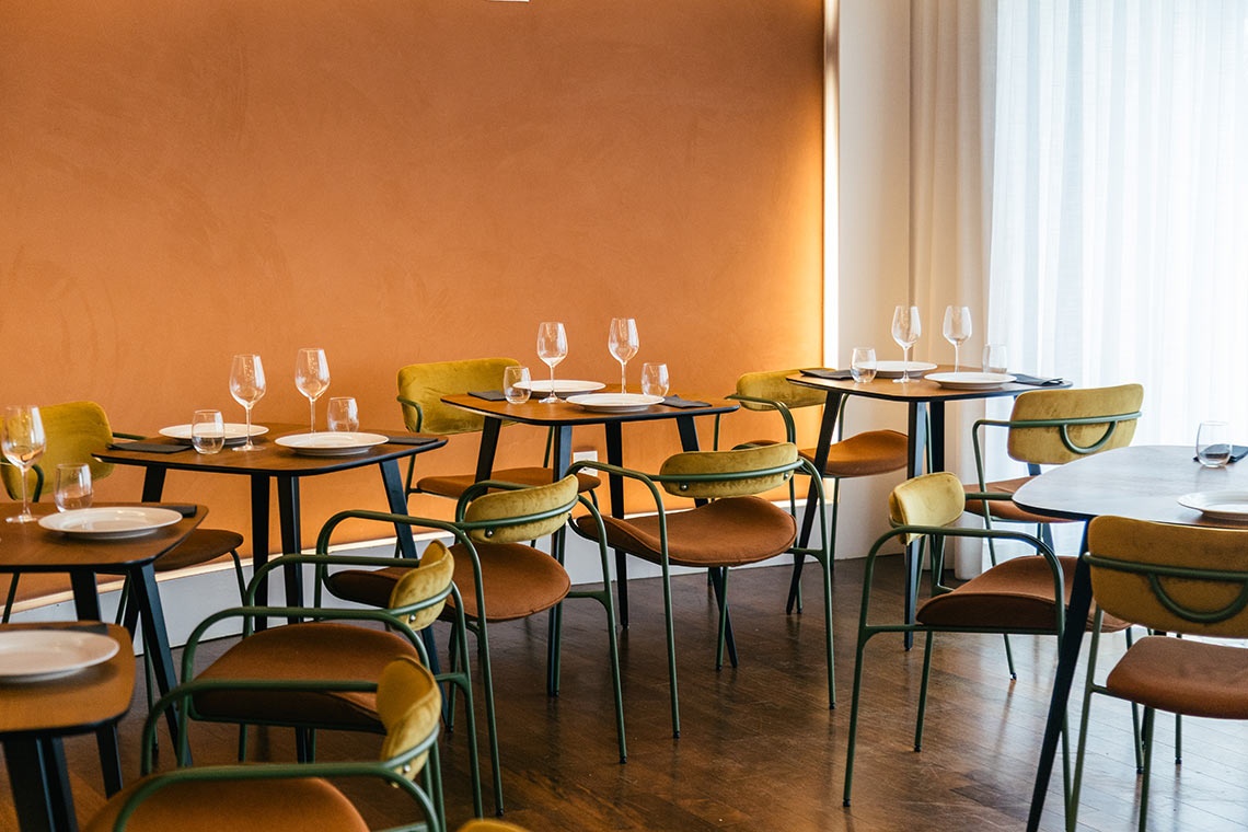 Mesas e cadeiras elegantes em restaurante AndTales.