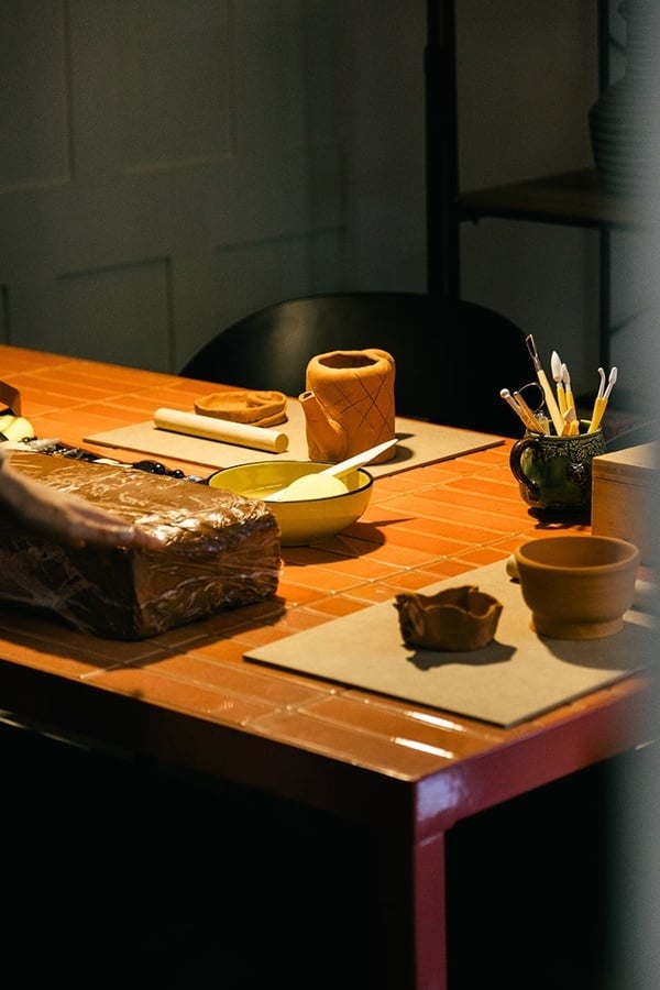 Mesa de cerâmica AndTales com argila e ferramentas. Perfeito para workshops criativos.