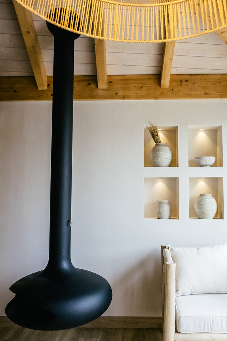 Modern fireplace with rustic decor in a AndTales hotel room.