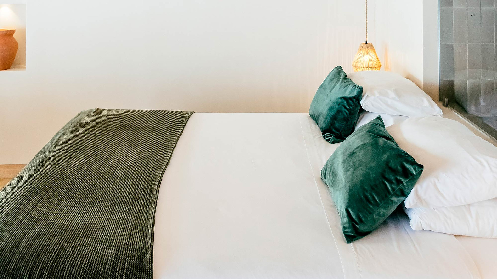 Quarto AndTales com teto de madeira e cama aconchegante.