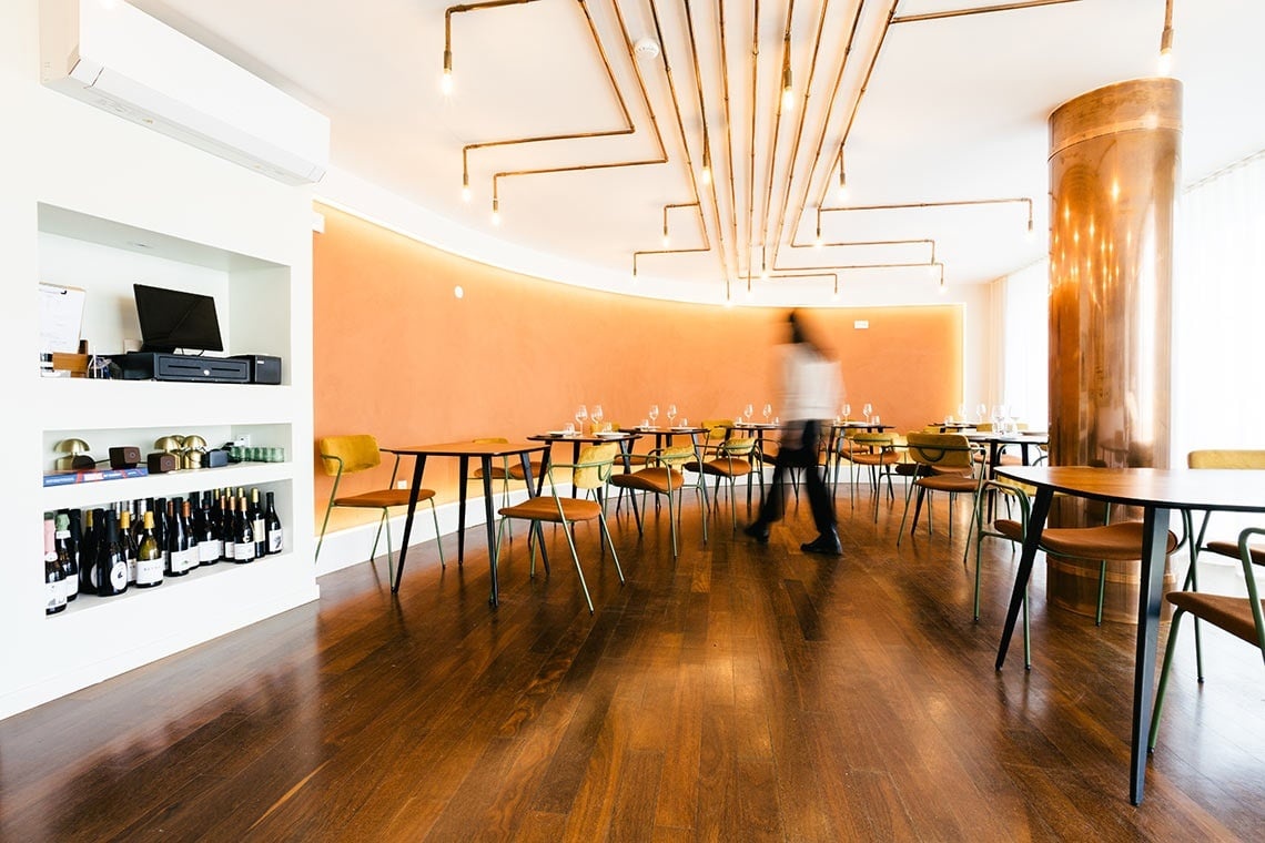 Ambiente elegante com mesas, cadeiras e decoração no AndTales.