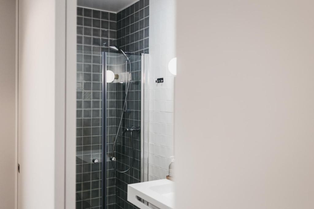 Modern hotel bathroom with stylish shower and sink, AndTales comfort.