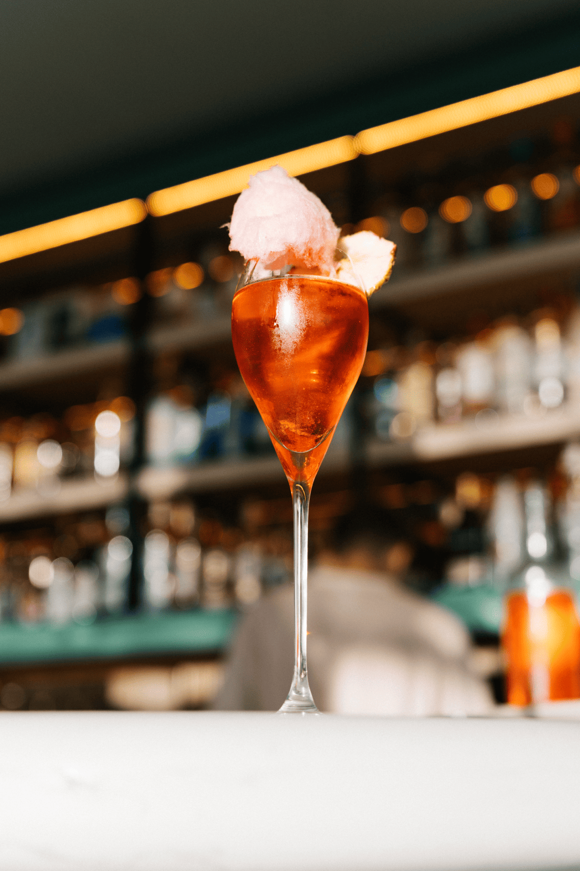 un verre de boisson avec une boule de barbe à papa sur le dessus