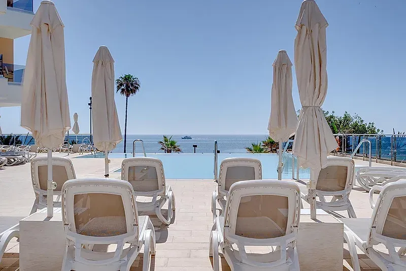 Relájate bajo el sol en Angela's Resort, junto a la piscina infinita y el mar.