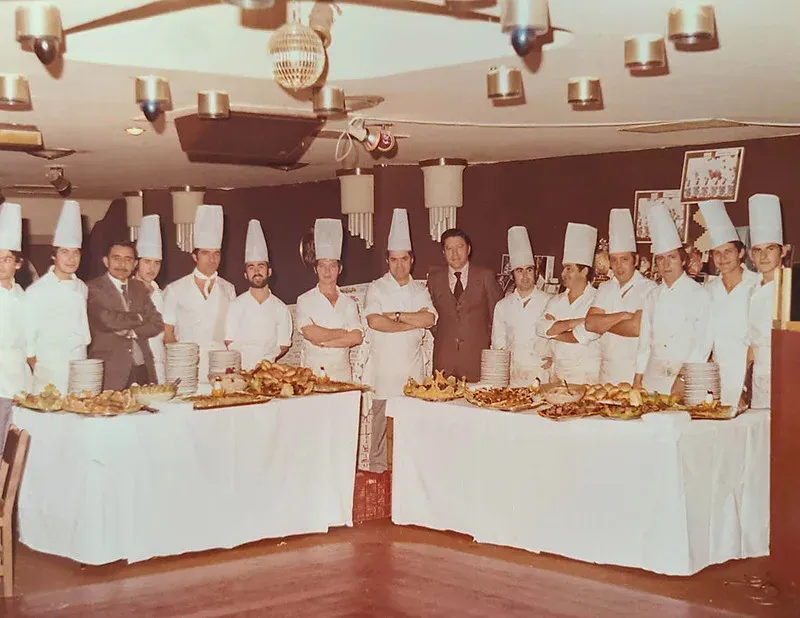Equipo de chefs de Ángela posando frente a un buffet en el hotel.