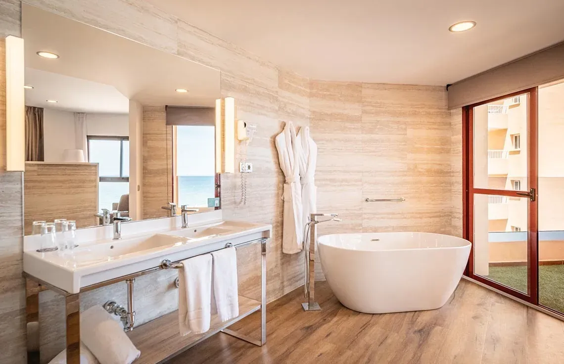 Elegante baño con bañera exenta y doble lavabo en Angela Suite.