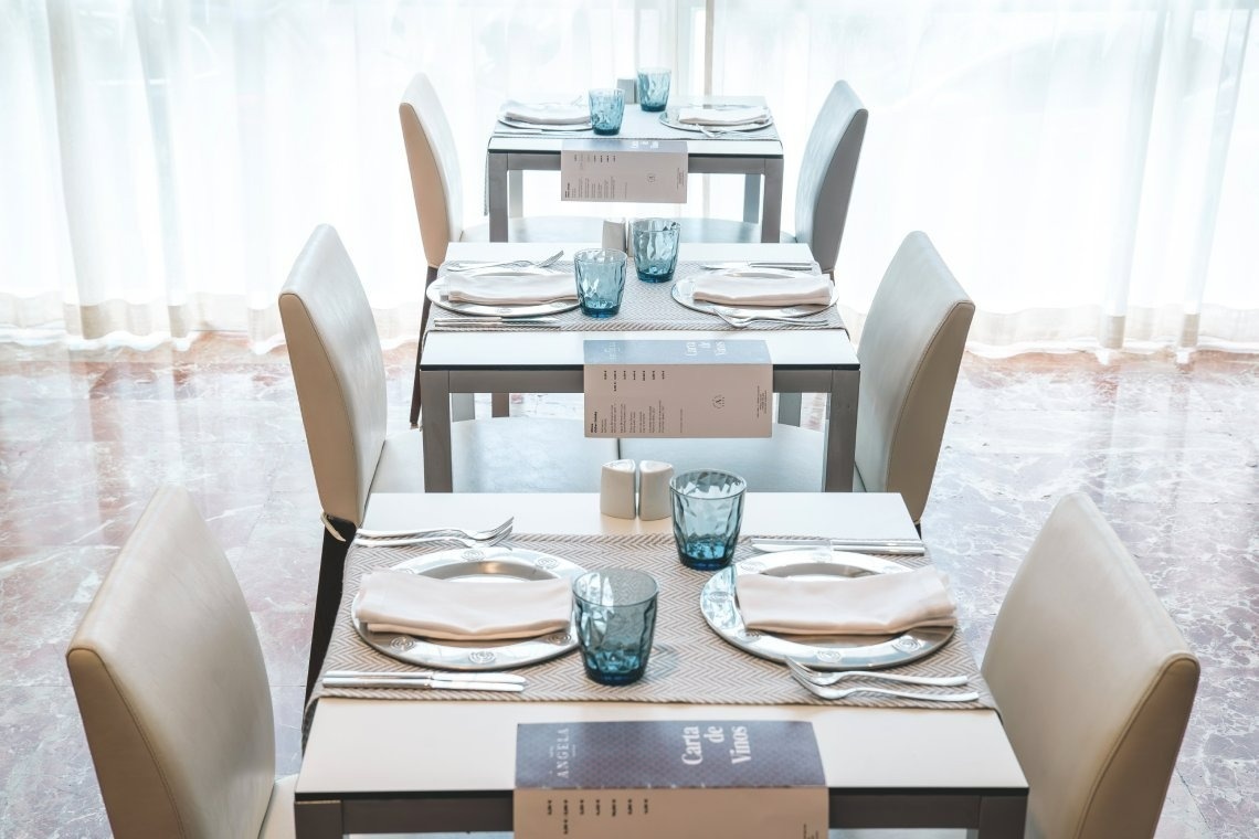 a row of tables and chairs with a menu on the table