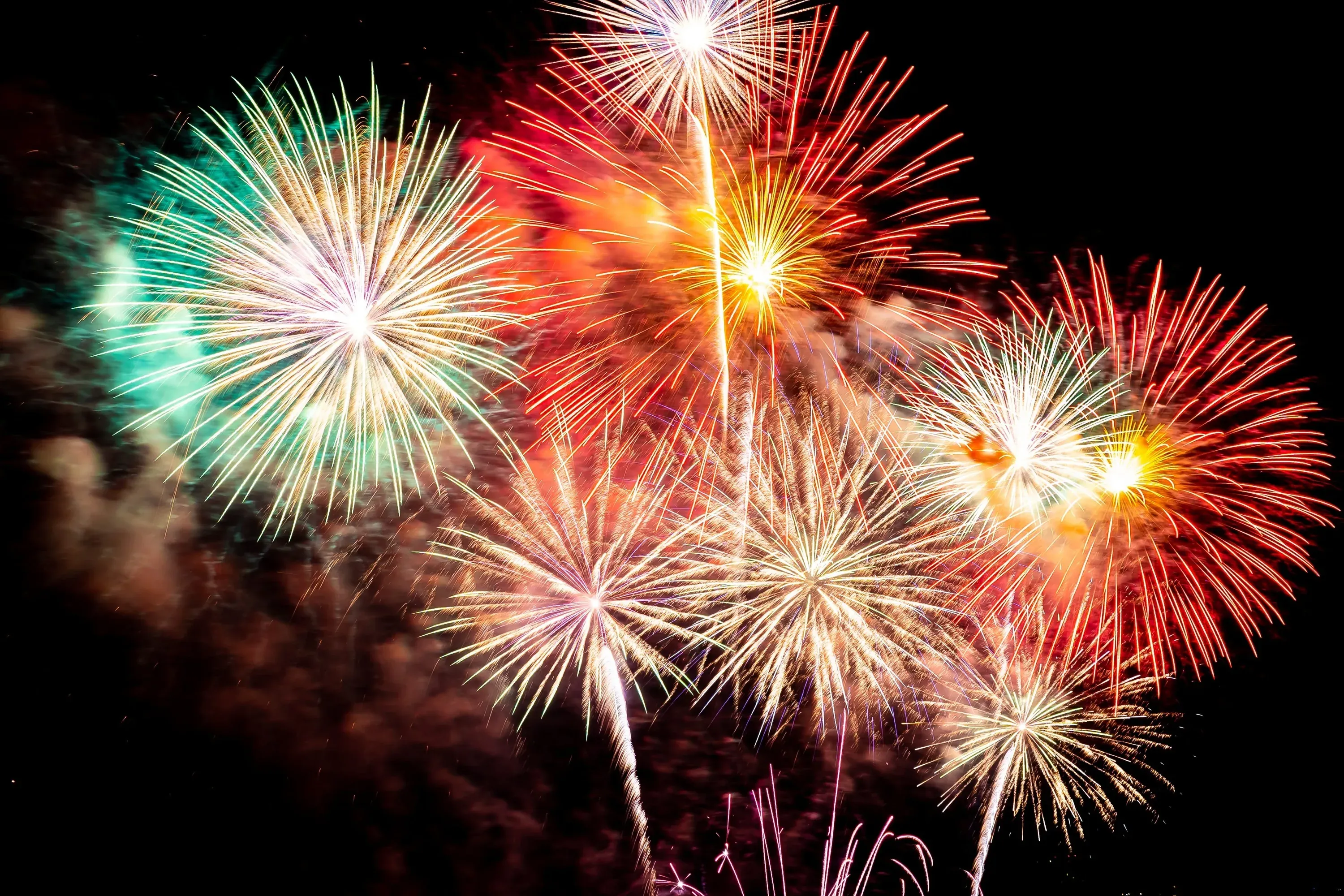 Spectacle de feux d'artifice au-dessus de l'hôtel Angela, une célébration nocturne éblouissante.