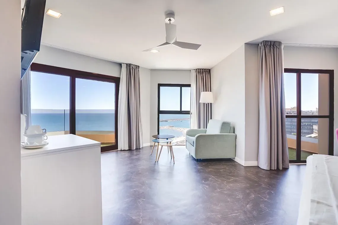 Luminosa habitación de hotel Angela con vistas al mar y balcón.
