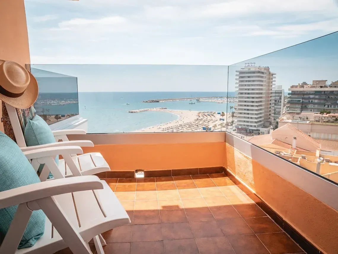 Balcón Angela con vistas al mar, playa y edificios modernos.