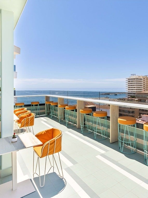 une terrasse avec des chaises et des tables avec vue sur l' océan