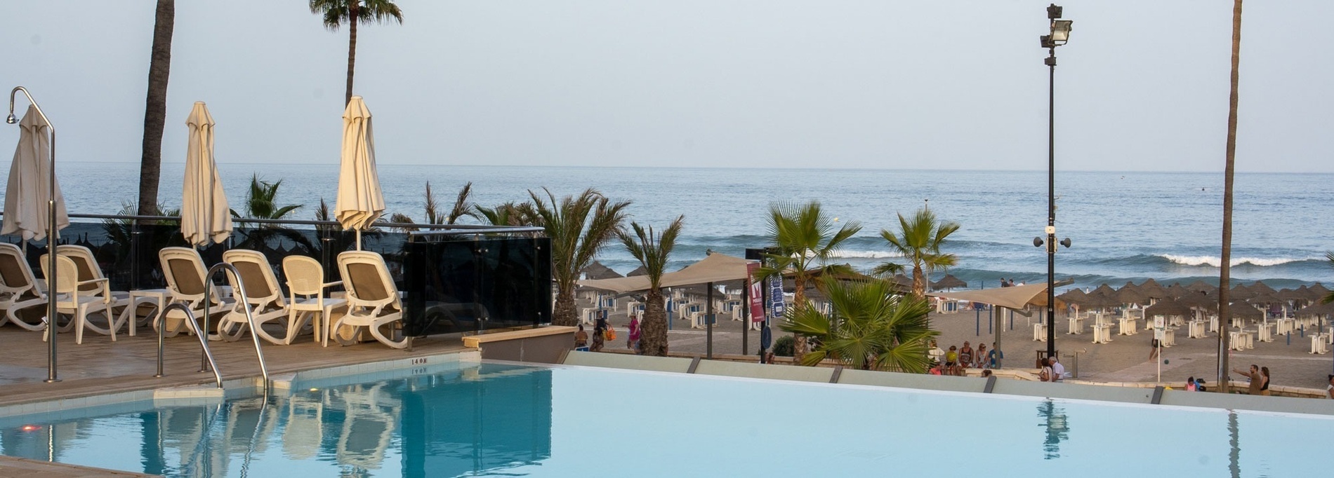 two chairs and a table on a balcony overlooking the ocean