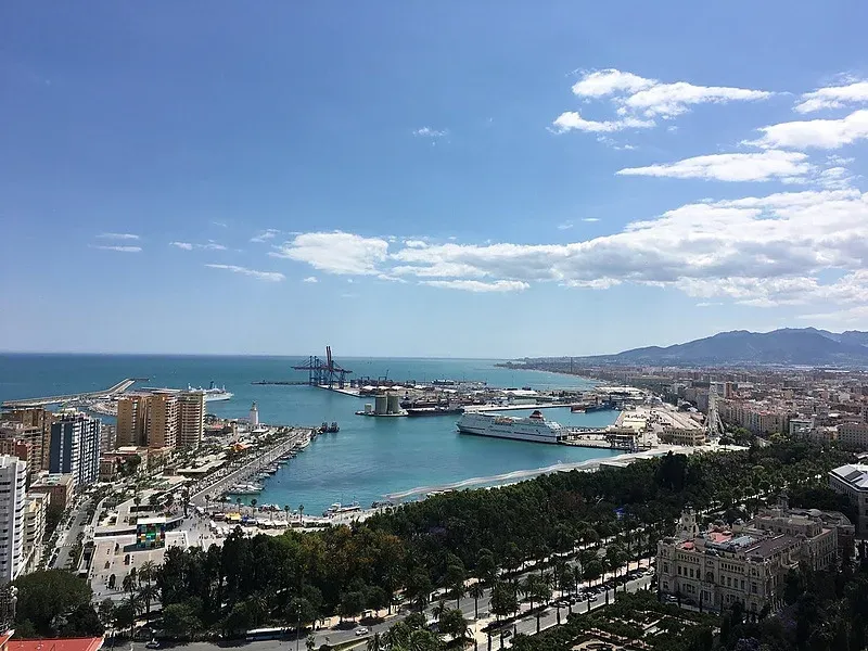 Vista aérea del puerto de Málaga, incluyendo el Hotel Angela, con cruceros y montañas.