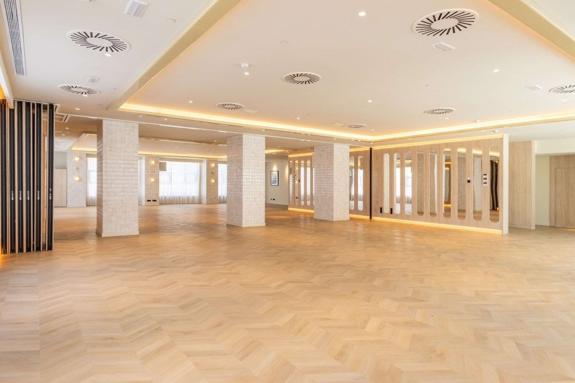 a large empty room with columns and a wooden floor