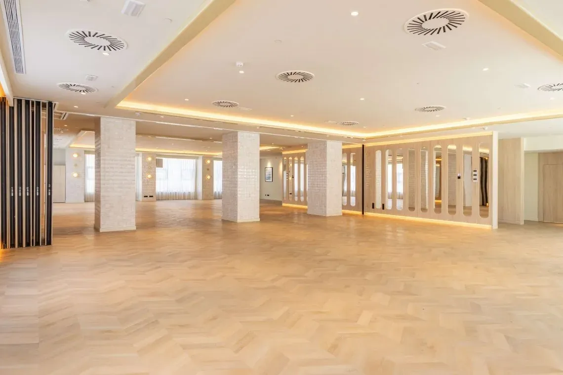 Elegante salón de eventos Angela con suelo de espiga y diseño moderno.