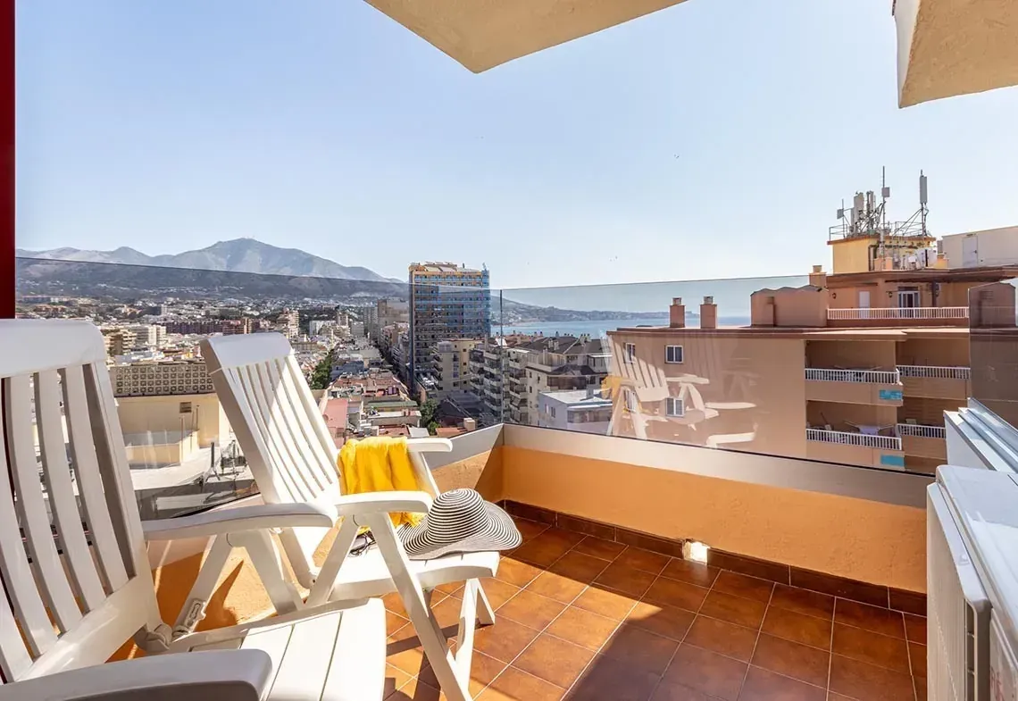 Terraza con vistas a la ciudad y al mar, con tumbonas y toalla. Perfecto para relajarse en el Ángela Hotel.