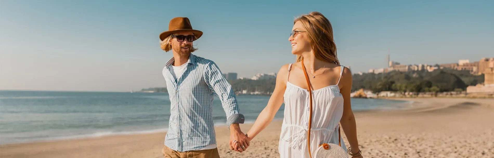 Jeune couple sur plage ensoleillée, parfait pour une escapade romantique à Angela.