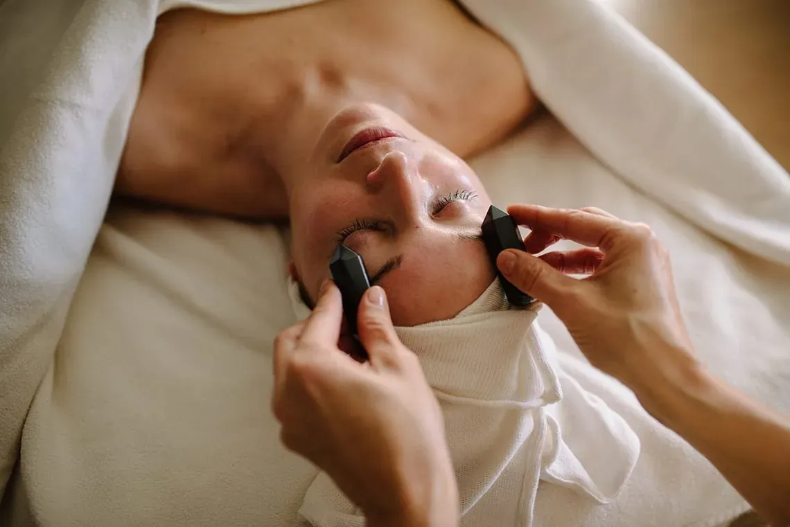Relajante masaje facial Angela con cristales negros para una experiencia rejuvenecedora.